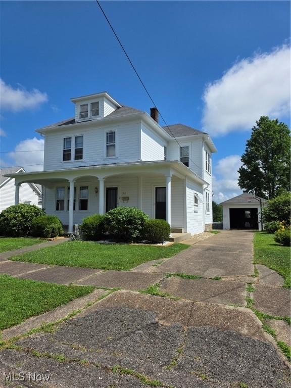 302 High St, Woodsfield, OH 43793 - view of front of property with an outdoor structure, driveway, covered porch, a garage, and a front lawn