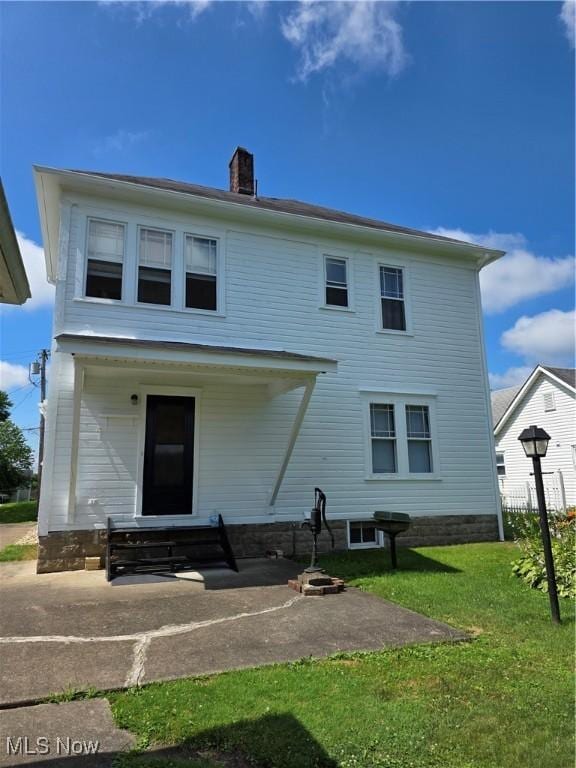302 High St, Woodsfield, OH 43793 - rear view of house with a chimney, a patio, a lawn, and a fire pit