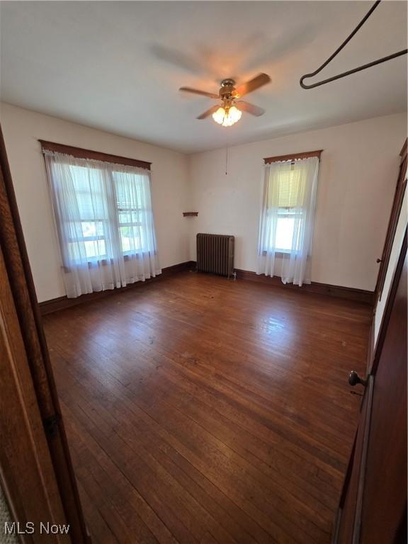 302 High St, Woodsfield, OH 43793 - unfurnished living room featuring radiator, a ceiling fan, and dark wood-type flooring
