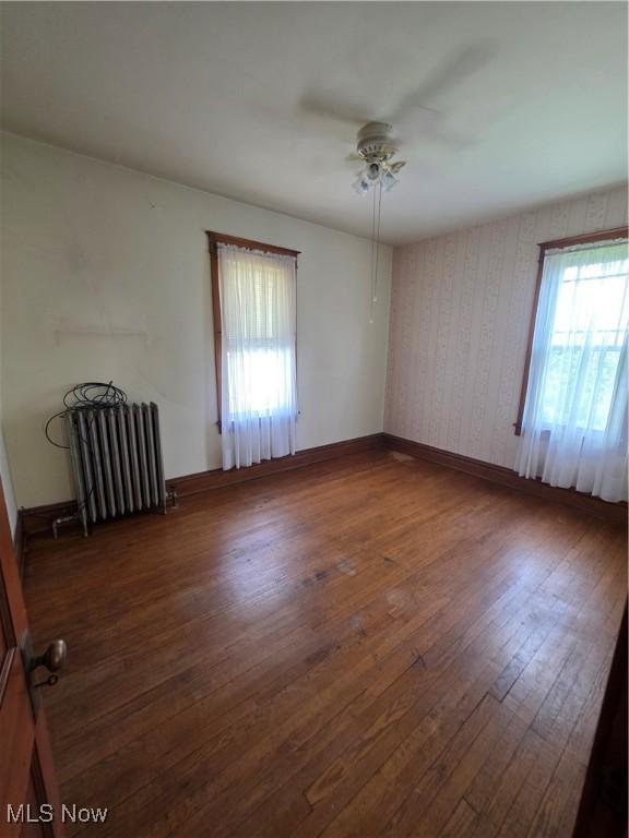 302 High St, Woodsfield, OH 43793 - empty room featuring radiator, plenty of natural light, ceiling fan, and wood finished floors