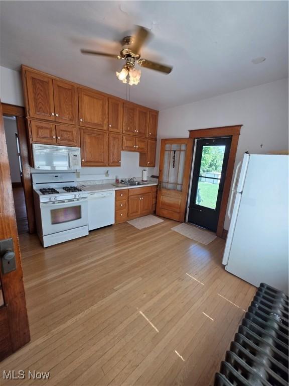 302 High St, Woodsfield, OH 43793 - kitchen featuring white appliances, light countertops, light wood-type flooring, a ceiling fan, and brown cabinetry