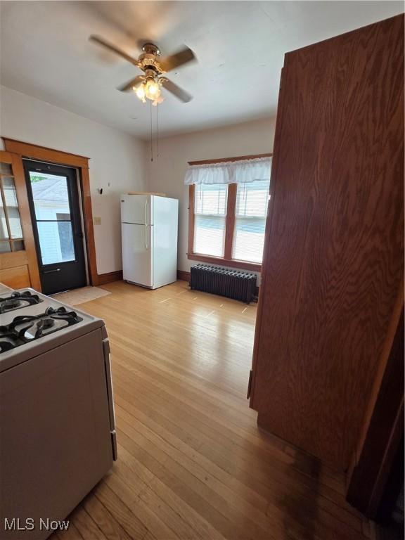 302 High St, Woodsfield, OH 43793 - kitchen with radiator heating unit, white appliances, plenty of natural light, and a ceiling fan