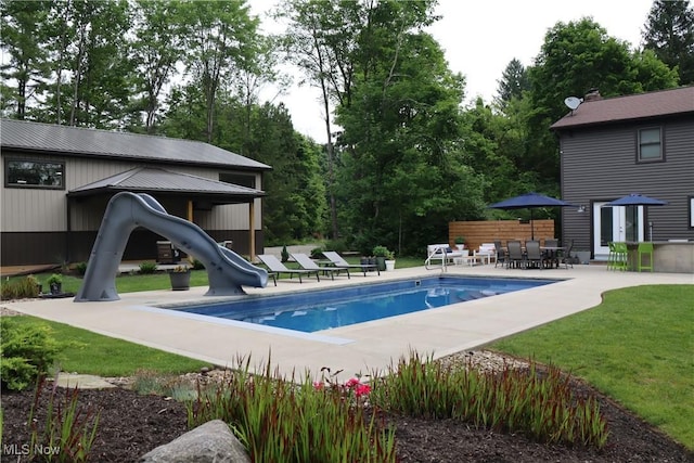 812 Spring Water Dr, Akron, OH 44333 - outdoor pool featuring a water slide, a patio, view of scattered trees, and a yard