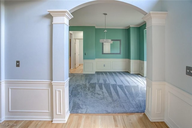 1741 Hamilton Dr, Broadview Heights, OH 44147 - unfurnished room featuring arched walkways, decorative columns, a decorative wall, wainscoting, and wood finished floors