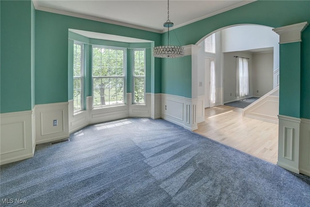 1741 Hamilton Dr, Broadview Heights, OH 44147 - empty room with carpet, healthy amount of natural light, arched walkways, crown molding, and a decorative wall