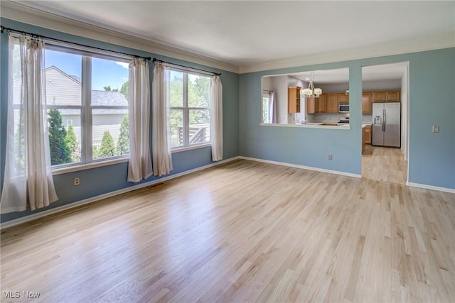 1741 Hamilton Dr, Broadview Heights, OH 44147 - unfurnished living room with ornamental molding, light wood-type flooring, and a chandelier
