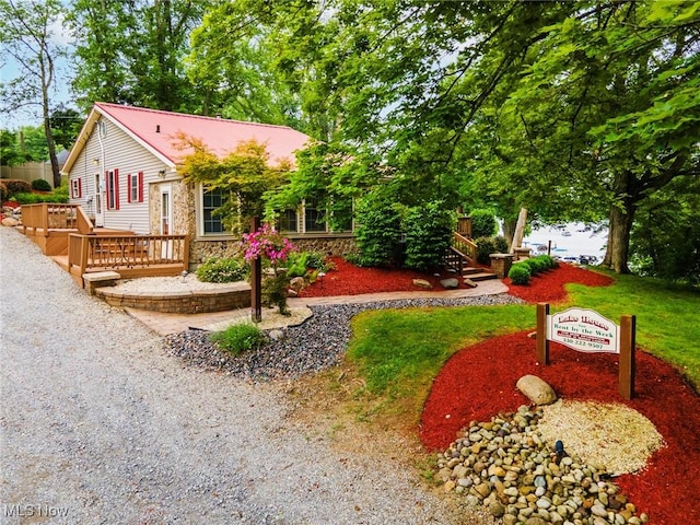 7235 Spillway Rd, Lisbon, OH 44408 - view of front of property featuring a wooden deck, stone siding, and a metal roof