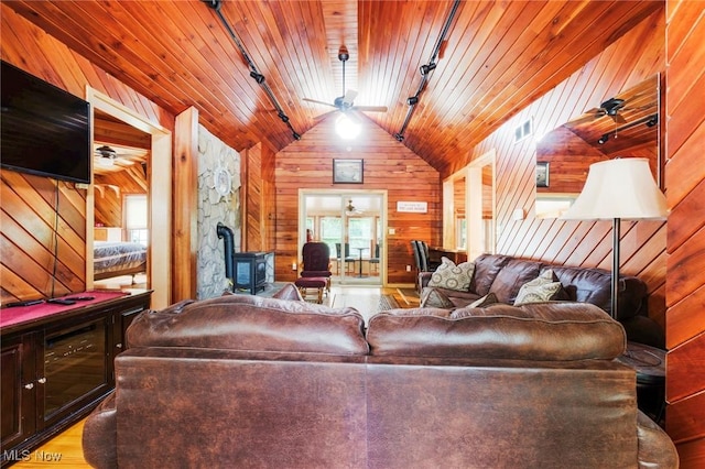 7235 Spillway Rd, Lisbon, OH 44408 - living area featuring track lighting, a wood stove, wooden walls, lofted ceiling, and wood ceiling