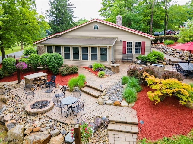 7235 Spillway Rd, Lisbon, OH 44408 - rear view of house with an outdoor fire pit, a patio area, a chimney, and outdoor dining area