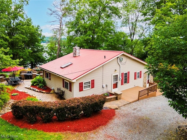 7235 Spillway Rd, Lisbon, OH 44408 - view of side of property with a patio area, a wooden deck, a metal roof, a chimney, and view of wooded area
