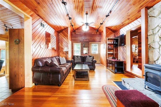 7235 Spillway Rd, Lisbon, OH 44408 - living room with track lighting, a wood stove, vaulted ceiling, wood ceiling, and plenty of natural light