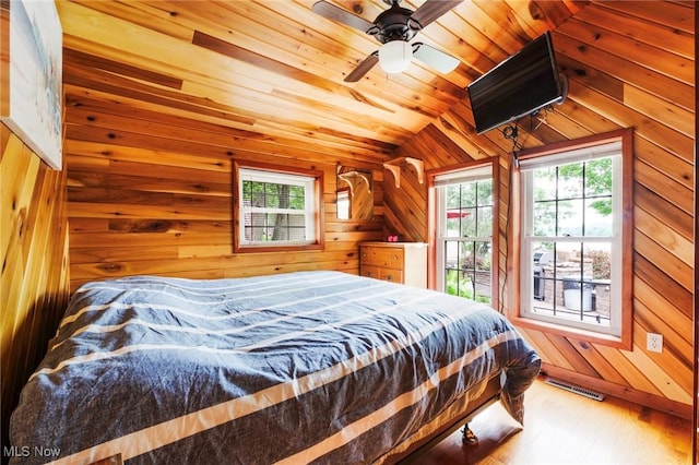 7235 Spillway Rd, Lisbon, OH 44408 - bedroom featuring wood walls, multiple windows, wood finished floors, and vaulted ceiling