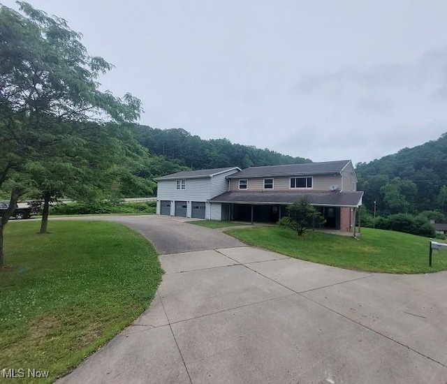 4985 State Route 213, Toronto, OH 43964 - view of front of house featuring a garage, a front lawn, asphalt driveway, and a forest view