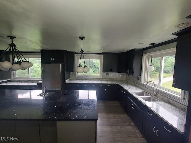 4985 State Route 213, Toronto, OH 43964 - kitchen with freestanding refrigerator, dark cabinetry, wood finished floors, decorative light fixtures, and decorative backsplash