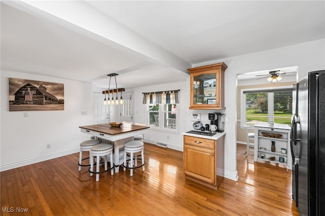 34765 Roberts Rd, Eastlake, OH 44095 - kitchen with freestanding refrigerator, light wood-type flooring, glass insert cabinets, and pendant lighting