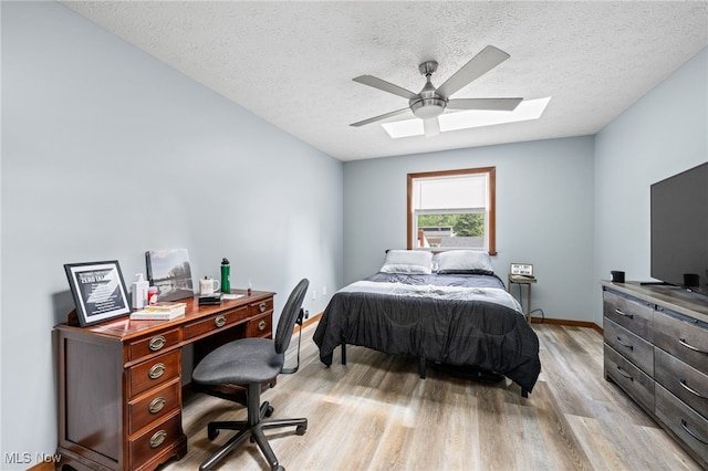 34765 Roberts Rd, Eastlake, OH 44095 - bedroom with a skylight, light wood finished floors, a textured ceiling, a desk, and a ceiling fan
