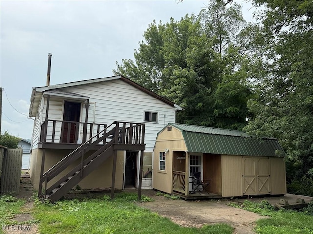 224 Shamrock Ave, Mingo Junction, OH 43938 - back of house with a metal roof, an outdoor structure, stairs, a wooden deck, and a gambrel roof