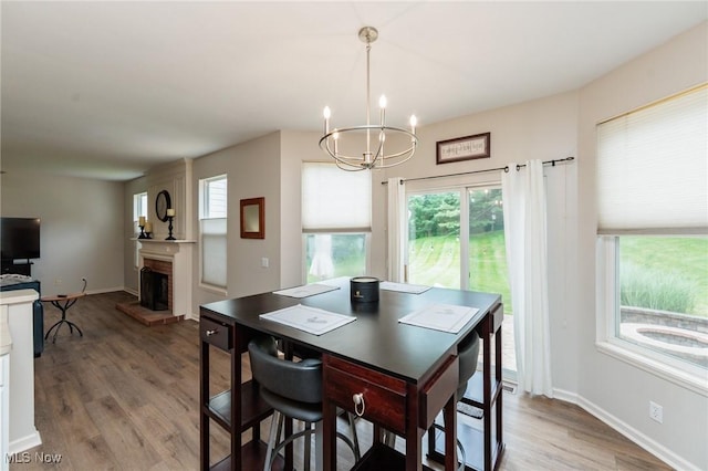 100 Hartford Ct, Broadview Heights, OH 44147 - dining area with a chandelier, a brick fireplace, healthy amount of natural light, and light wood-style flooring