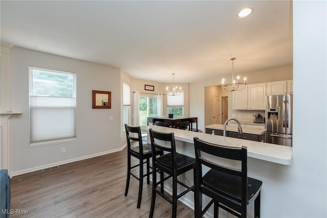 100 Hartford Ct, Broadview Heights, OH 44147 - kitchen featuring stainless steel fridge, a chandelier, a breakfast bar, white cabinets, and light countertops