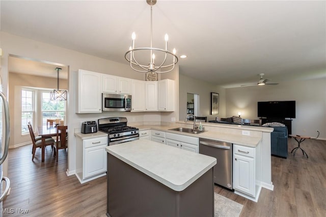 100 Hartford Ct, Broadview Heights, OH 44147 - kitchen with stainless steel appliances, a peninsula, a chandelier, wood finished floors, and white cabinets