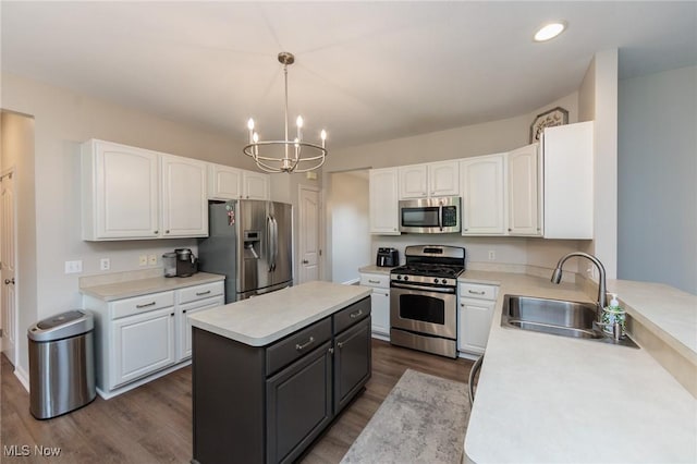 100 Hartford Ct, Broadview Heights, OH 44147 - kitchen featuring appliances with stainless steel finishes, a chandelier, white cabinetry, dark wood-style floors, and a center island