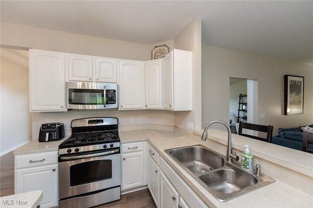 100 Hartford Ct, Broadview Heights, OH 44147 - kitchen with appliances with stainless steel finishes, white cabinets, light countertops, dark wood-style flooring, and open floor plan
