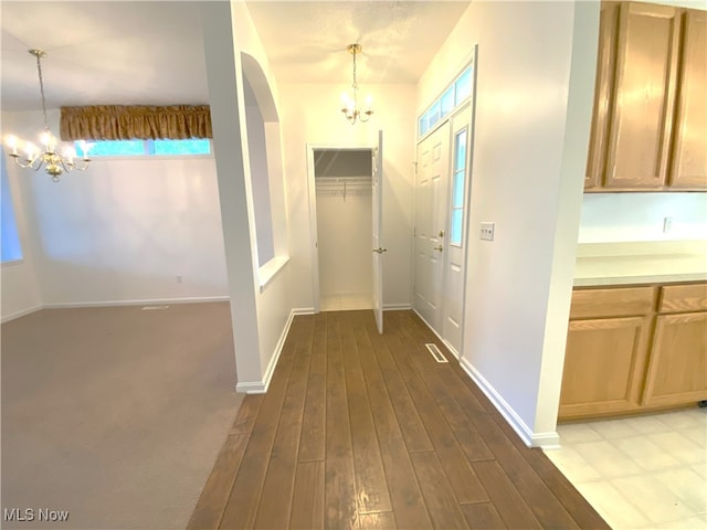 10517 W Ravine View Ct, North Royalton, OH 44133 - hallway with a chandelier, healthy amount of natural light, wood finished floors, and arched walkways