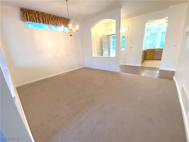 10517 W Ravine View Ct, North Royalton, OH 44133 - carpeted spare room with a chandelier, plenty of natural light, and arched walkways