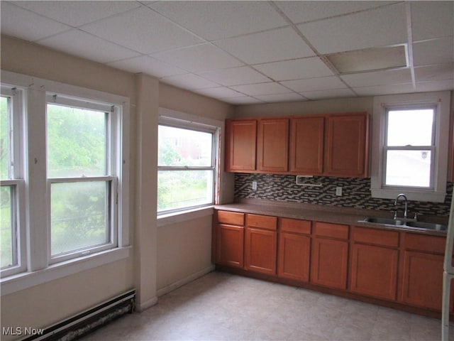 3298 E 143rd St, Cleveland, OH 44120 - kitchen featuring brown cabinetry, a baseboard radiator, tasteful backsplash, and a drop ceiling