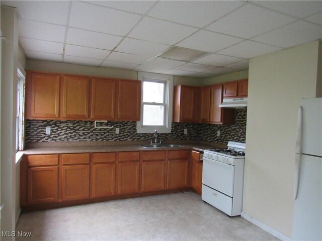 3298 E 143rd St, Cleveland, OH 44120 - kitchen featuring white appliances, under cabinet range hood, backsplash, brown cabinetry, and a paneled ceiling