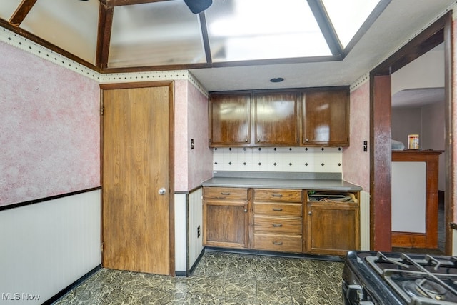 516 Floyd St, Akron, OH 44310 - kitchen featuring backsplash, brown cabinets, arched walkways, and a skylight