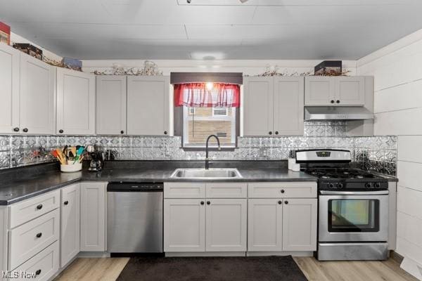 345 Ritchie Ave, Weirton, WV 26062 - kitchen with appliances with stainless steel finishes, under cabinet range hood, light wood-style floors, and dark countertops