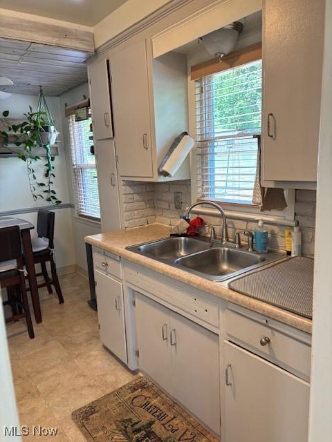 1129 Avondale Rd, South Euclid, OH 44121 - kitchen with backsplash, light countertops, plenty of natural light, and white cabinetry