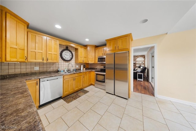 1141 Las Olas Blvd NW, North Canton, OH 44720 - kitchen featuring stainless steel appliances, backsplash, dark countertops, light tile patterned floors, and recessed lighting