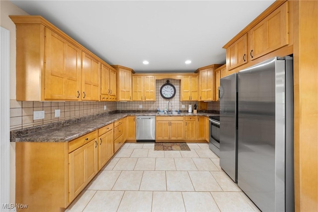 1141 Las Olas Blvd NW, North Canton, OH 44720 - kitchen featuring stainless steel appliances, decorative backsplash, light tile patterned flooring, recessed lighting, and dark stone countertops