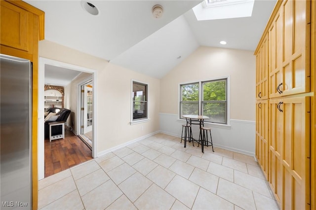 1141 Las Olas Blvd NW, North Canton, OH 44720 - empty room featuring a skylight, light tile patterned floors, vaulted ceiling, and a smoke detector