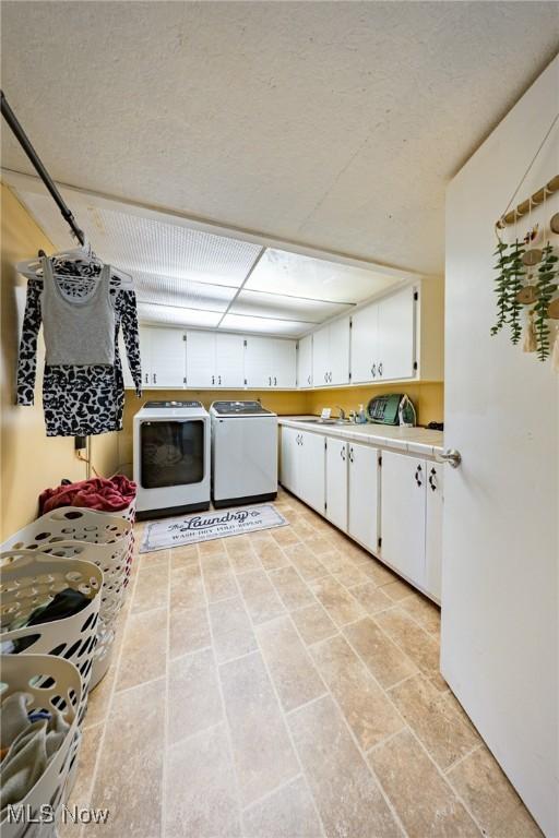 1141 Las Olas Blvd NW, North Canton, OH 44720 - kitchen featuring washer and dryer, white cabinetry, and light countertops