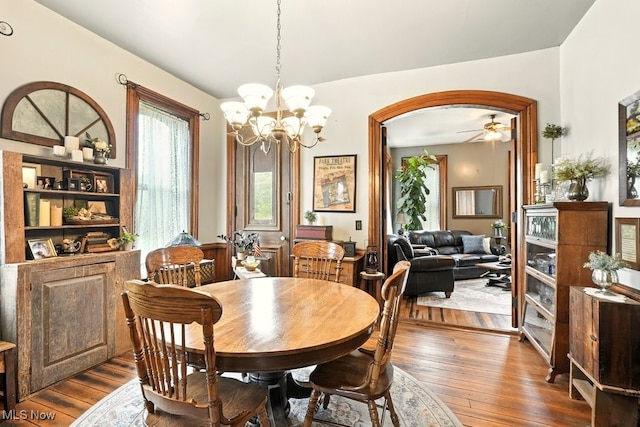 7298 Akron Rd, Sterling, OH 44276 - dining space featuring dark wood-style floors, a chandelier, arched walkways, and ceiling fan