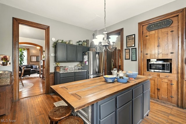 7298 Akron Rd, Sterling, OH 44276 - kitchen with appliances with stainless steel finishes, butcher block countertops, a chandelier, and hardwood / wood-style floors
