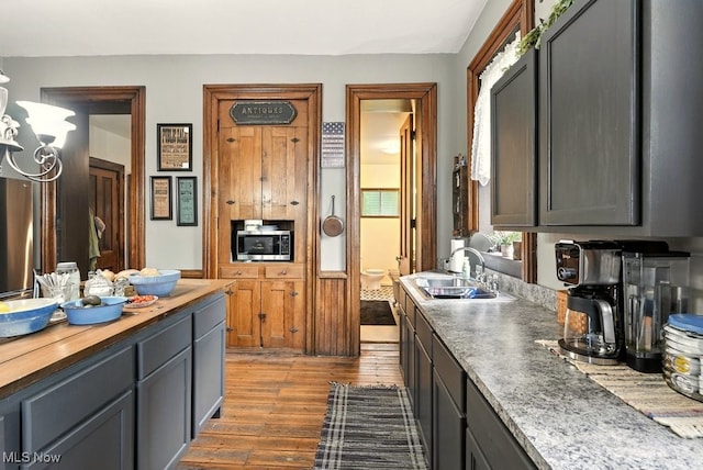 7298 Akron Rd, Sterling, OH 44276 - kitchen featuring stainless steel microwave, wood finished floors, wooden counters, and a chandelier