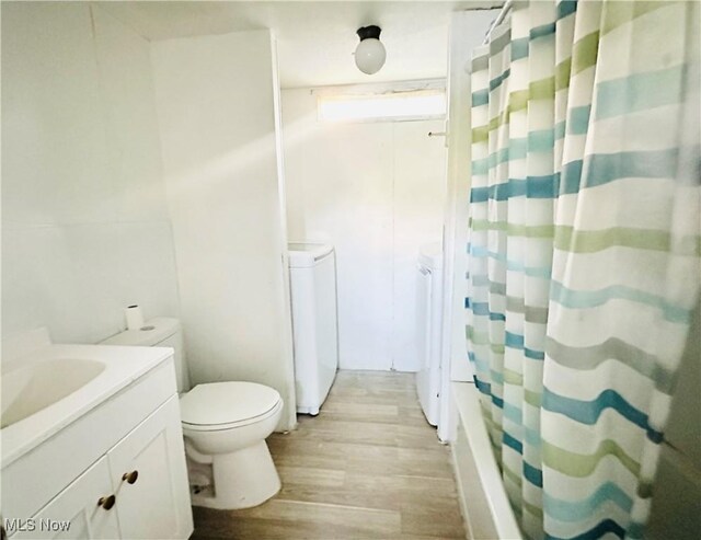 121 Yorktown Dr, Wintersville, OH 43953 - bathroom with washing machine and dryer, wood finished floors, vanity, and shower / tub combo