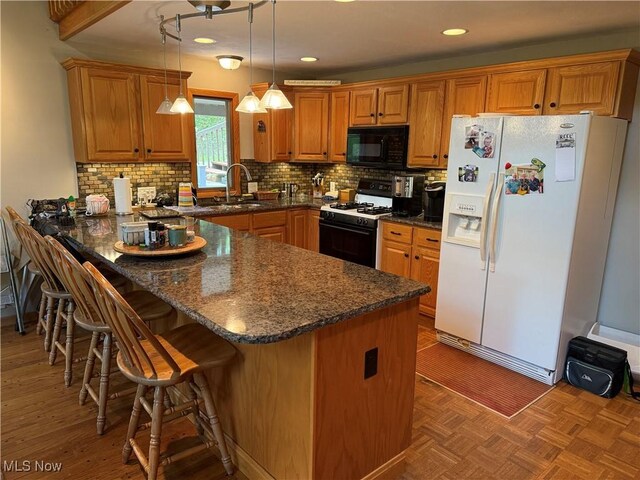 2650 W Buckhorn Dr Unit 823, Millersburg, OH 44654 - kitchen with white fridge with ice dispenser, black microwave, gas stove, a peninsula, and brown cabinets
