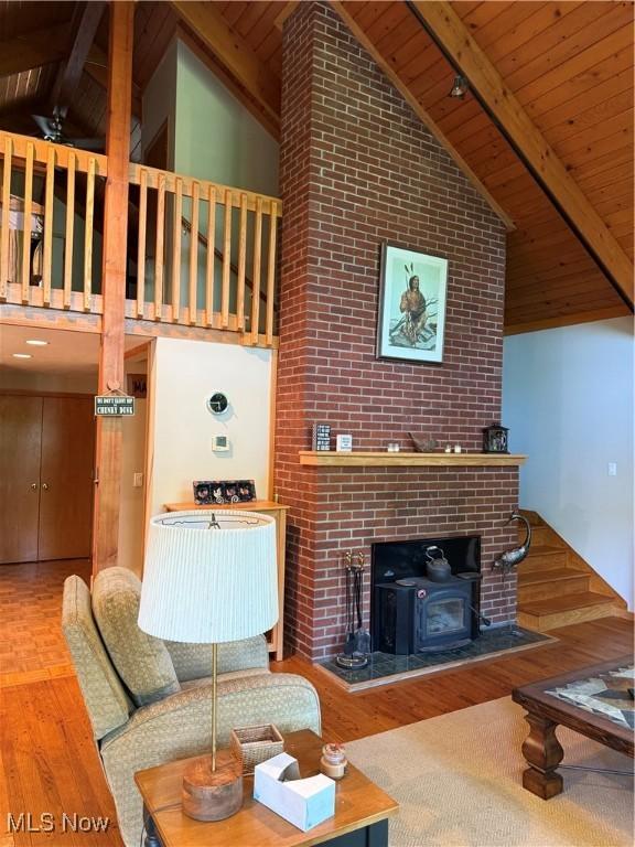2650 W Buckhorn Dr Unit 823, Millersburg, OH 44654 - living room featuring high vaulted ceiling, a wood ceiling with exposed beams, wood finished floors, and a wood stove