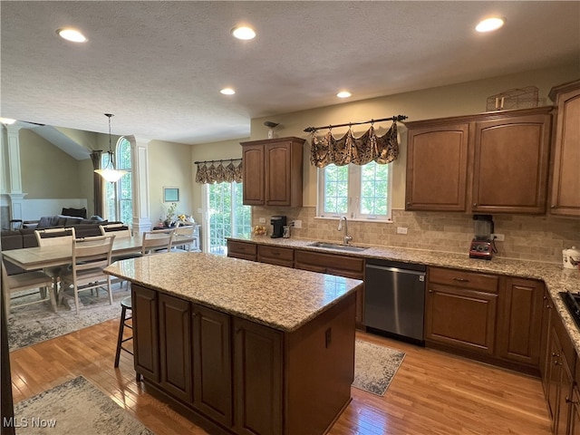 7149 Cascade Creek Ln, Independence, OH 44131 - kitchen featuring dishwasher, light wood-style floors, a kitchen island, decorative backsplash, and a textured ceiling