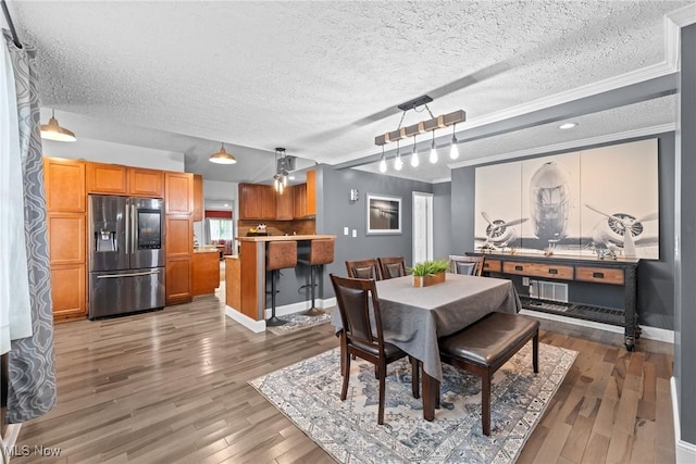 208 Clark St, Berea, OH 44017 - dining room with a textured ceiling, wood finished floors, and crown molding