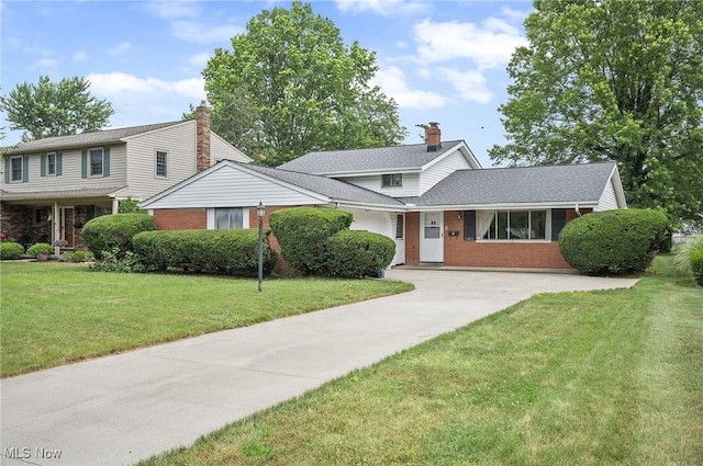 24622 Mitchell Dr, North Olmsted, OH 44070 - traditional-style home featuring a front lawn, brick siding, concrete driveway, and a chimney