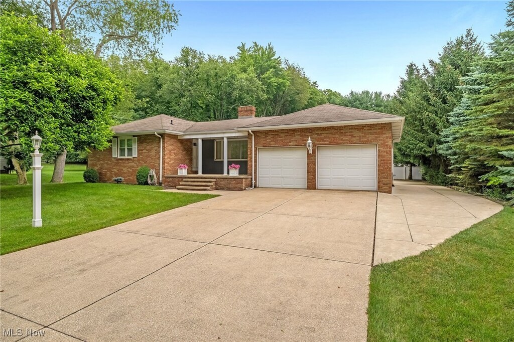 7140 Lake O Springs Ave NW, North Canton, OH 44720 - single story home with brick siding, an attached garage, a chimney, driveway, and a front lawn