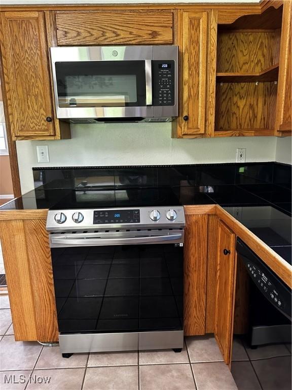 54431 Maple Ln, Martins Ferry, OH 43935 - kitchen with appliances with stainless steel finishes, brown cabinets, and light tile patterned floors