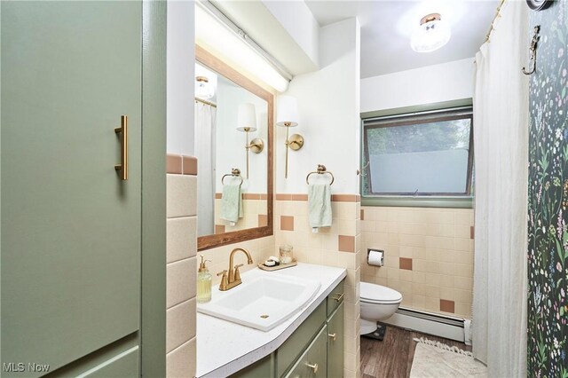 661 Wynne Dr, Coventry, OH 44319 - full bathroom with baseboard heating, vanity, tile walls, a wainscoted wall, and wood finished floors