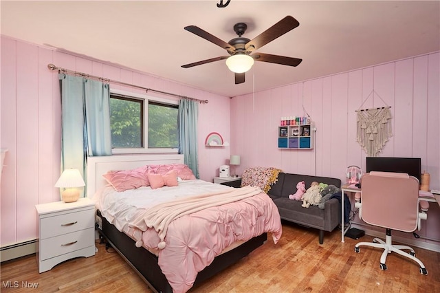 661 Wynne Dr, Coventry, OH 44319 - bedroom with baseboard heating, wood finished floors, and ceiling fan